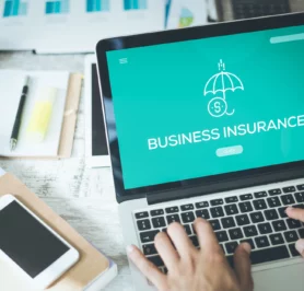 person reviewing types of business insurance on a laptop